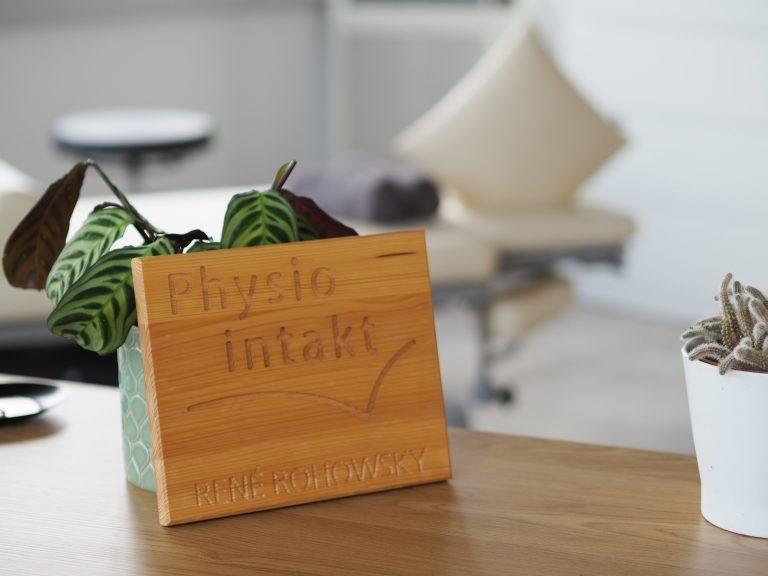 Detailbild - Logo der Praxis auf Holzbrett